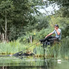 Wędkarz wyciąga rybę z wody. Czy to okres ochronny okonia?